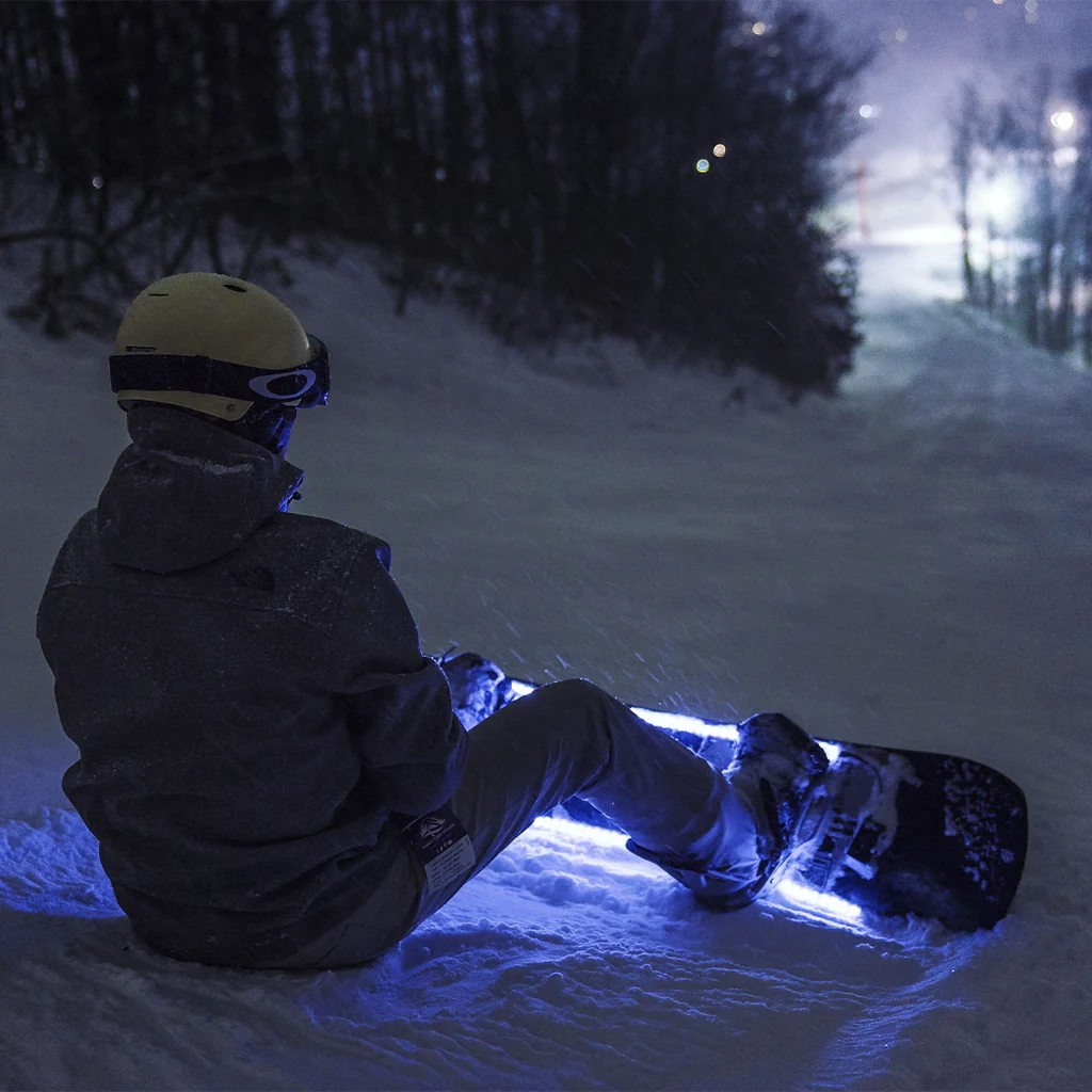 Snowboard SkiiGlow illuminato di blu sulla neve