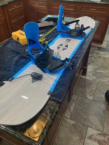 Snowboard bianco con luci SkiiGlow azzurre, foto inviata da un cliente